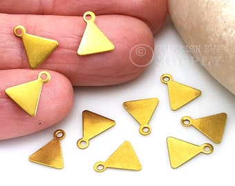 May include: Ten gold triangle charms with a loop at the top. The charms are about 1 inch in size.