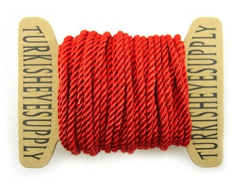 May include: A spool of red twisted cord with the text "TURKISH EYES SUPPLY" printed on the cardboard spool.