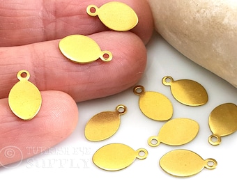 May include: Ten gold oval-shaped metal charms with a jump ring for attaching to jewelry or other crafts. The charms are blank and ready to be personalized.
