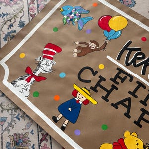 May include: Hand-painted artwork on brown paper featuring cartoon characters like The Cat in the Hat, Curious George, and Winnie the Pooh. The artwork includes colorful balloons, fish, and the text "Keep the Happy".