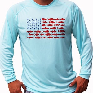 Puede incluir: Una camiseta de manga larga azul claro con un diseño de bandera estadounidense roja, blanca y azul hecha de siluetas de peces.