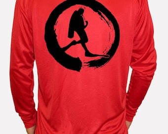 May include: Red long-sleeved shirt with a black circle graphic of a scuba diver in a stylised brushstroke design.