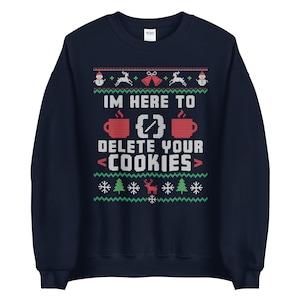 May include: Navy blue sweatshirt with a festive, pixelated design. The text "IM HERE TO DELETE YOUR COOKIES" is displayed in white, along with images of mugs, snowflakes, reindeer, bells, and Christmas trees. A humorous Christmas jumper.