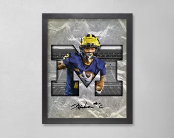 Peut inclure: Œuvre encadrée représentant un joueur de football américain en uniforme bleu et jaune, intégré dans un grand « M ». Le fond a un aspect texturé et gris. Le joueur tient un ballon. Signé par Blake Corum.