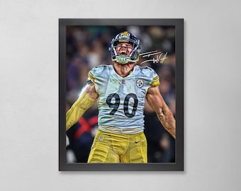 Op de afbeelding: Ingelijste print van een American footballspeler in een wit en geel uniform, nummer 90, met een zwarte helm. De speler viert met open mond en opgeheven armen. De achtergrond is wazig met andere spelers en fans.