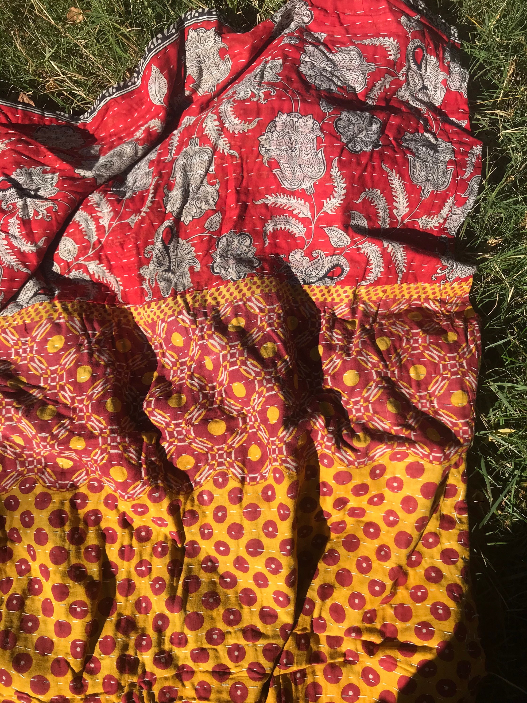 Sofa top kantha red orange and yellow bedspread with cashmere patterns and geometric shapes.