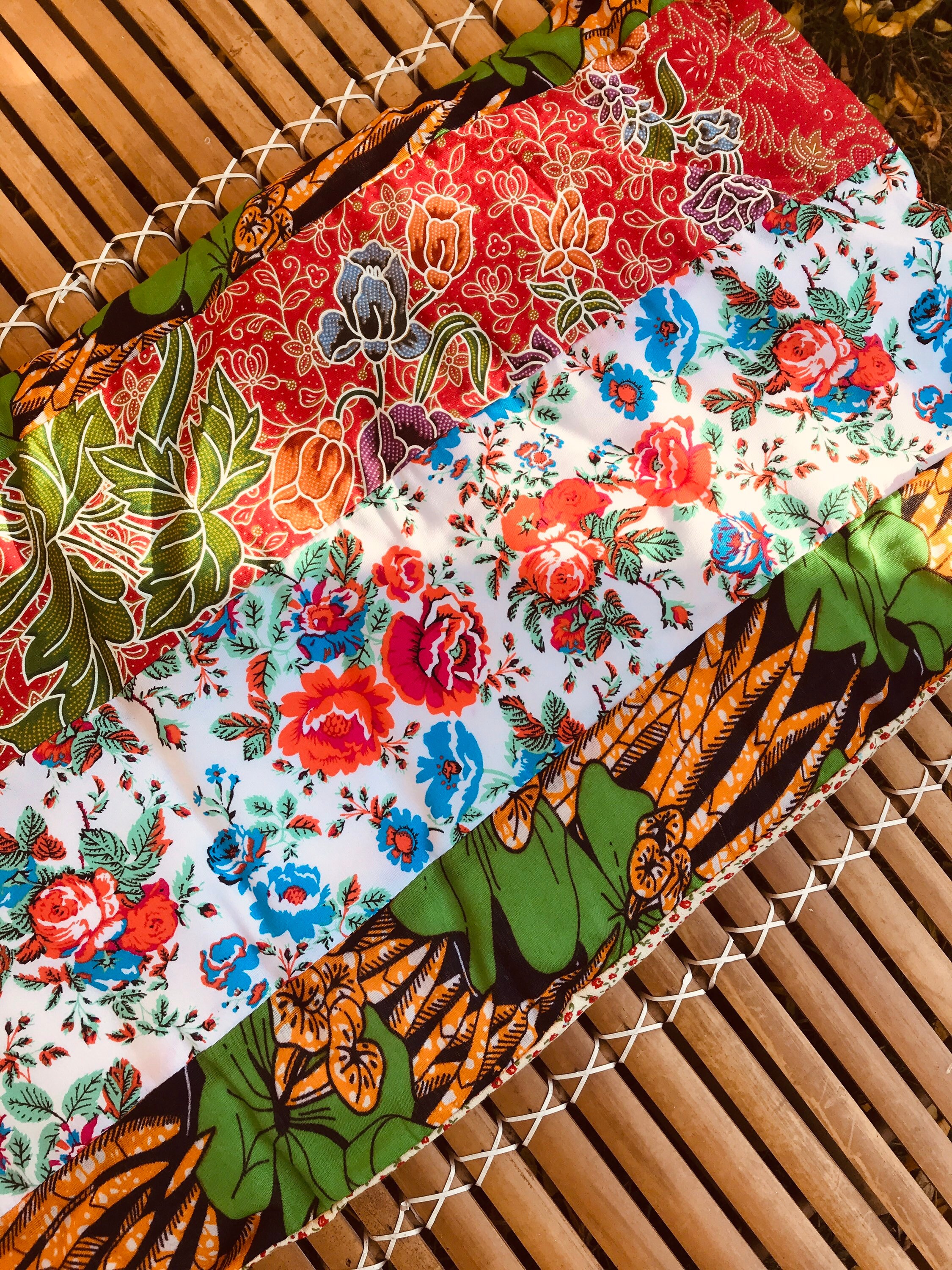 Coussin Plat en Patchwork Fait-Main Piece Unique Wax et Sarong Fleuris Rouge, Blanc, Vert Orange.