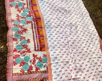 Sofa top top kantha bedspread predominantly white and red with turquoise orange and red flowers and tiles