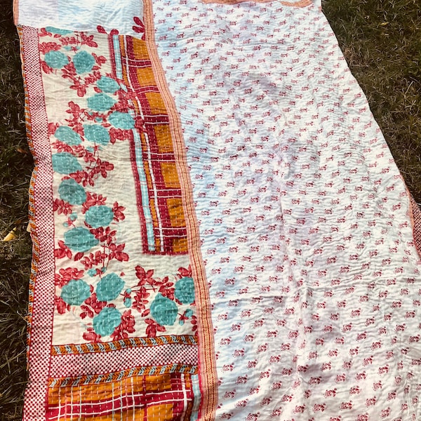 Sofa top top kantha bedspread predominantly white and red with turquoise orange and red flowers and tiles