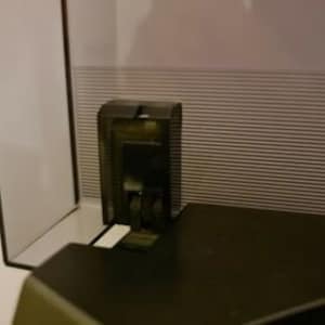 Puede incluir: Un tocadiscos de vinilo negro de plástico con un brazo de lectura negro de plástico y una cubierta antipolvo negra de plástico. El tocadiscos está sobre una superficie negra.