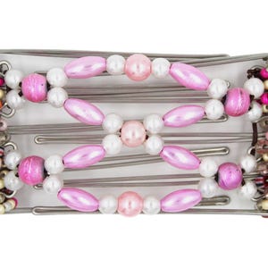 May include: A hair comb featuring a series of silver-toned metal wires adorned with a central pattern of pink oval beads and small white round beads. The sides are decorated with clusters of multi-colored beads in pink, white, and clear tones.