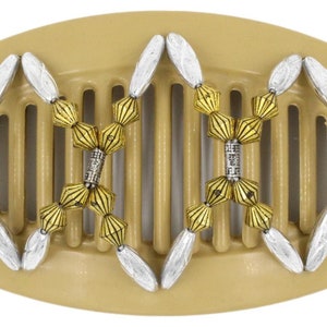 May include: A beige plastic hair comb with gold and silver beads. The comb has a curved shape and a row of teeth. The beads are arranged in a decorative pattern.
