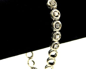 May include: A silver bracelet with a chain of round links, each set with a small clear diamond.