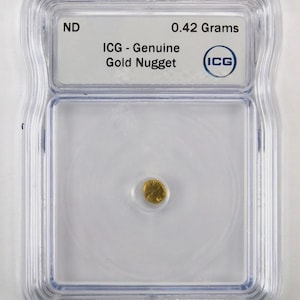 May include: A small, genuine gold nugget weighing 0.42 grams, encased in a clear, rectangular ICG protective plastic slab. The label at the top reads ND, 0.42 Grams, ICG - Genuine Gold Nugget, and features the ICG logo in a blue circle.