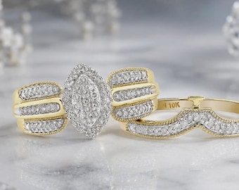 May include: A 10K gold bridal ring set featuring a marquise-shaped centre cluster of small round diamonds. The main ring has three rows of diamonds on each side, while the matching chevron-shaped band is also encrusted with small round diamonds.