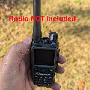 May include: A black Baofeng radio with a screen, buttons, and antenna. The text "Radio NOT included" is displayed in red. The radio is held in a hand against a blurred outdoor background.