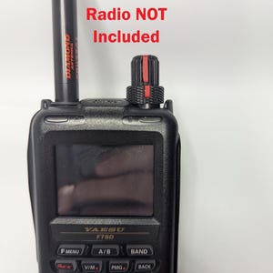 Peut inclure: Radio portable noir avec écran et boutons. Une antenne noire avec le texte rouge "DIAMOND ANTENNA" est attachée. Le texte "Radio NOT Included" est en rouge. Le radio a le texte "YAESU FT5D".