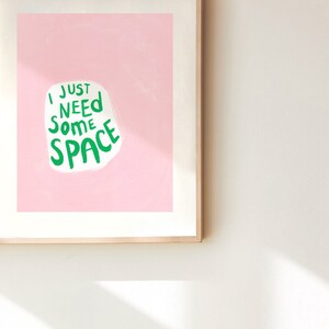 Op de afbeelding: Een ingelijst print met een roze achtergrond en witte tekst die "Ik heb gewoon wat ruimte nodig" in het groen zegt.