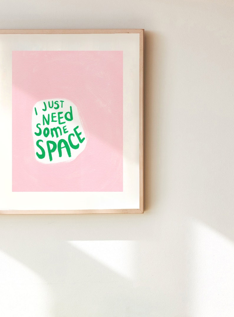 Op de afbeelding: Een ingelijst print met een roze achtergrond en witte tekst die "Ik heb gewoon wat ruimte nodig" in het groen zegt.