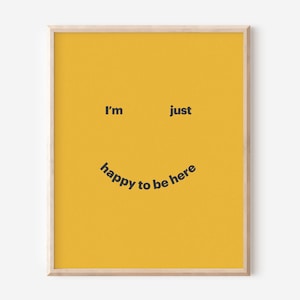 May include: A yellow poster with black text that reads "I'm just happy to be here" in a curved arc, forming a smiley face.