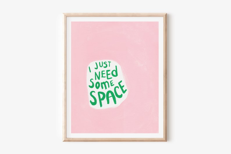 Op de afbeelding: Een roze ingelijste print met de tekst "I just need some space" in groene letters op een witte achtergrond.