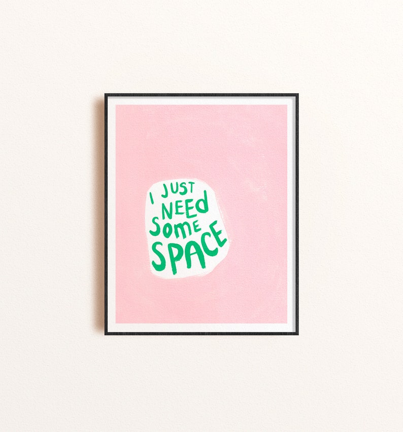 Op de afbeelding: Een ingelijst print met een roze achtergrond en een witte wolk met de tekst "I just need some space" in groene letters.