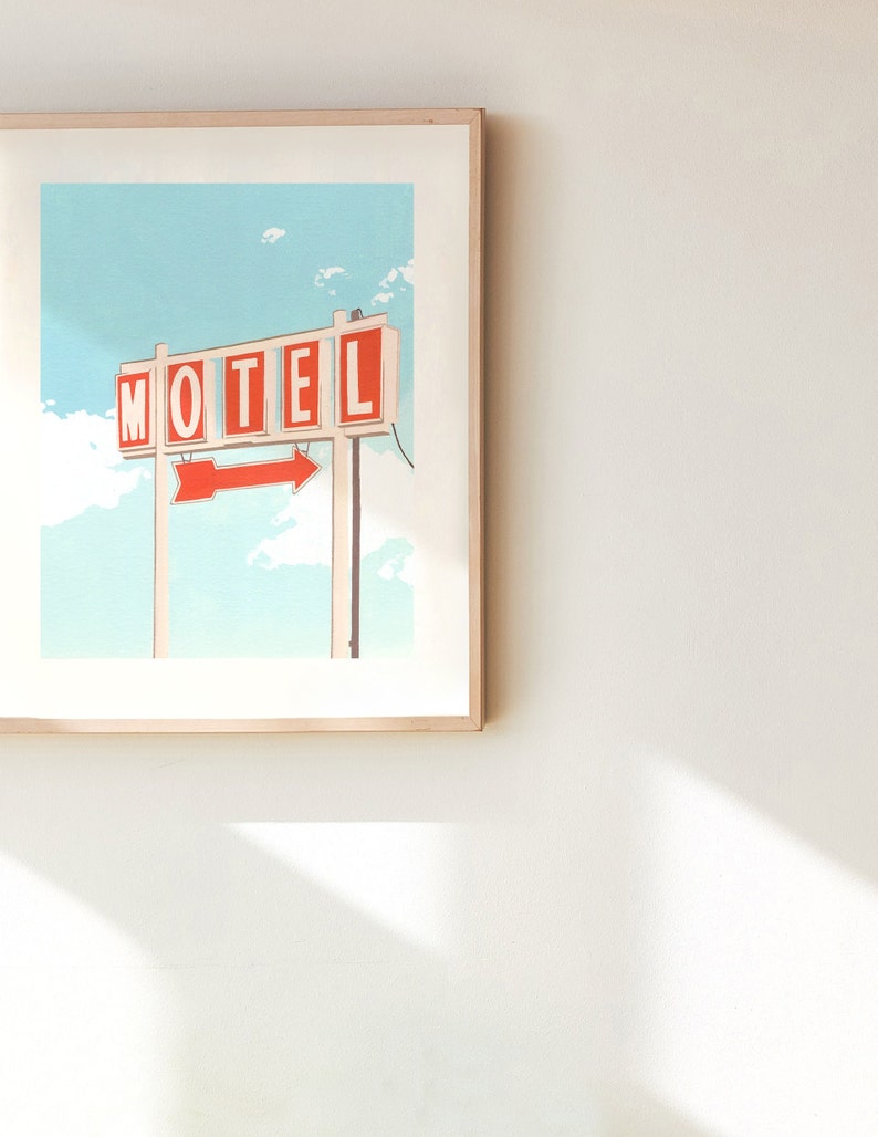 May include: A framed illustration of a vintage motel sign with the word "MOTEL" in red letters and a red arrow pointing to the right. The sign is against a blue sky with white clouds.