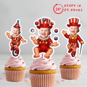 May include: Three cupcakes with circus baby toppers. Each baby wears a red and white striped outfit and hat. The cupcakes have pink icing and are ready in 24 hours.