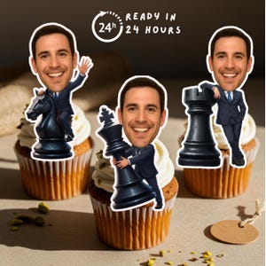 May include: Three cupcakes topped with smiling cartoon faces and chess pieces. The chess pieces are a black knight, king, and rook. The text "READY IN 24 HOURS" is in a circle above the cupcakes.