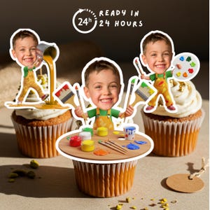 Op de afbeelding: Drie cupcakes versierd met cartoonafbeeldingen van een jongen als kunstenaar. De jongen houdt penselen, een palet en een verfpot vast. De cupcakes hebben witte glazuur en zijn versierd met gouden sprinkles. De tekst "READY IN 24 HOURS" staat op de achtergrond.