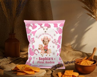 以下が含まれることがあります： カウガールをテーマにしたピンク色のパーティー記念品バッグ。バッグには、サボテンと花に囲まれた、馬に乗った子供の漫画の画像が描かれています。バッグのテキストは「Sophia's First Rodeo」と書かれています。