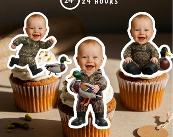 May include: Three cupcakes topped with smiling baby figures in camouflage outfits, each holding or near a duck figurine. The cupcakes have white frosting and are on a light brown surface. Text reads "READY IN 24 HOURS".