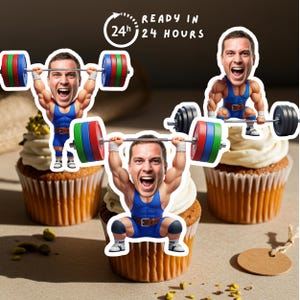 May include: Three cupcakes topped with white frosting and edible images of a weightlifter. The weightlifter is wearing a blue uniform and lifting a barbell with colorful weights. The text "READY IN 24 HOURS" is in a circle.