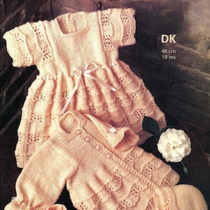 May include: A pale peach knitted baby set including a short-sleeved dress with a ribbon tie, a long-sleeved button-front cardigan, a pair of booties with ribbon bows, and a bonnet with a ribbon tie. The text reads DK 46 cm 18 ins.