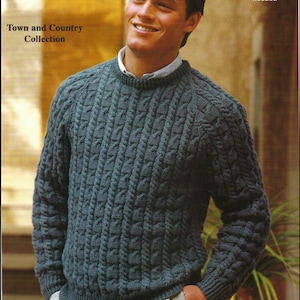 May include: A teal cable-knit sweater with a crew neck. The sweater is part of the "Town and Country Collection" and features the text "DOUBLE KNITTINGS". The image also includes the measurements 32-42 in and 81-107 cm.