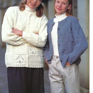 May include: Two knitted cardigans, one in cream and one in blue, both featuring a textured square pattern with eyelet details. The cream cardigan has a round neckline and buttons, while the blue cardigan is open-front with buttons and long sleeves.