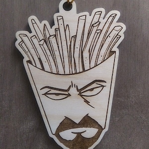 May include: A wooden ornament shaped like a face with a beard and a container of french fries on top of the head.