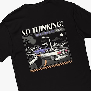 May include: Black t-shirt with a graphic of two cars drifting on a road at night. The text "NO THINKING! ONLY DRIFT!! ドリフト" is printed on the shirt.