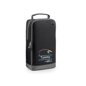 May include: Black zippered duffel bag with a gray trim. The bag has a fishing rod, reel, and fish embroidered on the front. The name "Tommy" is embroidered below the fishing rod.