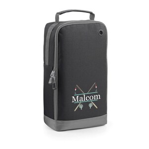 Puede incluir: Bolsa para zapatos negra y gris con cierre de cremallera y asa. La bolsa tiene un dise&ntilde;o de dos ca&ntilde;as de pescar cruzadas con un carrete de pesca y un flotador rojo en cada ca&ntilde;a. El nombre "Malcolm" est&aacute; impreso en letras blancas debajo de las ca&ntilde;as de pescar.
