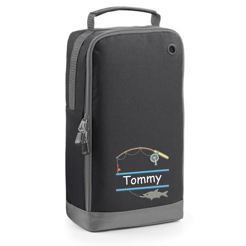 May include: Black shoe bag with a gray zipper and a gray bottom. The bag has a fishing rod and fish design with the name "Tommy" printed on it.