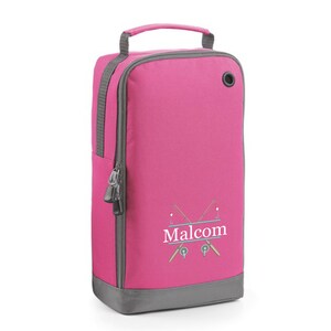 Puede incluir: Bolsa de zapatos rosa con cierre de cremallera y asa gris. La bolsa tiene una base gris y un dise&ntilde;o blanco de dos ca&ntilde;as de pescar cruzadas con el nombre "Malcolm" escrito en una pancarta.