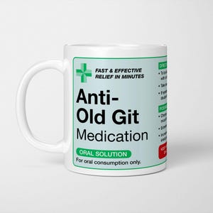 Peut inclure: Mug en céramique blanche avec une étiquette verte et blanche indiquant "Anti-Old Git Medication". L'étiquette comprend le texte "Soulagement rapide et efficace en quelques minutes" et "Solution orale". La tasse a une anse blanche.