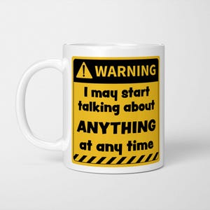 May include: A white ceramic mug featuring a yellow and black rectangular warning sign graphic. The text reads WARNING I may start talking about ANYTHING at any time, with a hazard symbol and diagonal black and yellow stripes at the bottom.