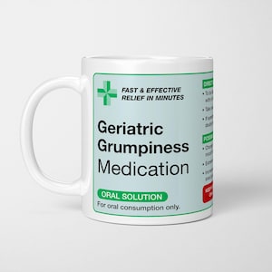 May include: White ceramic mug with the words "Geriatric Grumpiness Medication" in black text. The mug also features the text "Fast & Effective Relief in Minutes" and "Oral Solution". A green cross symbol is also present.