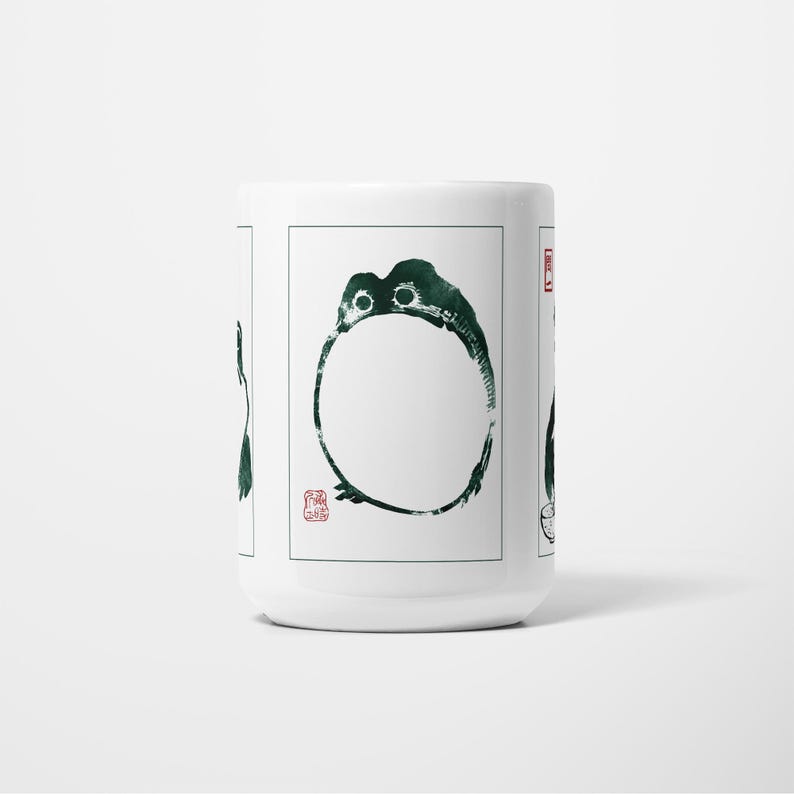 May include: White ceramic mug with a dark green ink illustration of a circular design with a stylized creature. The design includes a red stamp. The mug is a simple, elegant design.