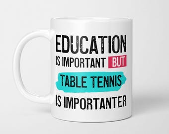 May include: A white ceramic mug featuring black text that reads EDUCATION IS IMPORTANT BUT TABLE TENNIS IS IMPORTANTER. The word BUT is highlighted in a pink rectangle, and the words TABLE TENNIS are set against a bright turquoise brush stroke.
