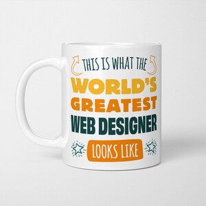 May include: White ceramic mug with a black, yellow, and orange design. The text on the mug reads "This is what the world's greatest web designer looks like".