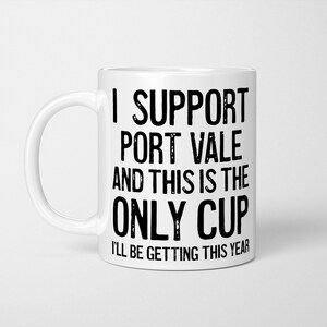 May include: A white ceramic mug featuring black text that reads I SUPPORT PORT VALE AND THIS IS THE ONLY CUP I'LL BE GETTING THIS YEAR. The mug has a standard handle on the left side and a smooth, cylindrical body with a clean, minimalist design.