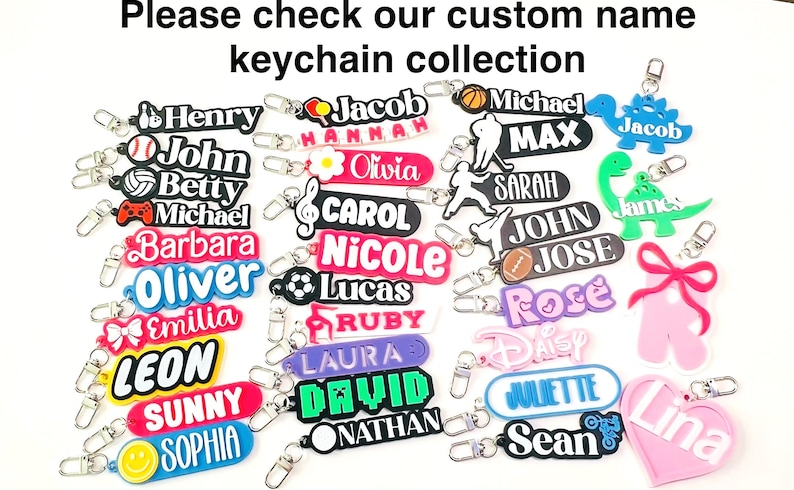May include: A collection of custom name keychains in various colors and shapes. Keychains include names like "Henry", "Jacob", "Michael", and "Sarah". Some keychains feature sports-themed designs, while others have cartoon characters.